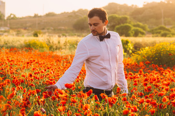 Man  in poppy field on the dusk