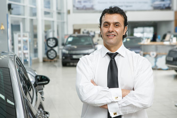 Professional car salesman working at the dealership salon