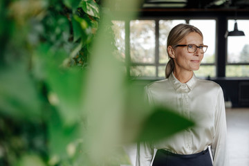 Smiling businesswoman in green office