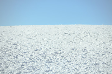 Compacted fresh snow against blue sky. Sunny day. Background with copy space for text. Winter time