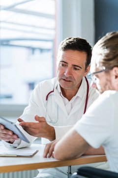 Doctor showing tablet to patient in medical practice