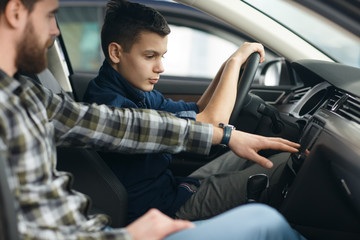 Handsome mature man and his young son buying a new automobile together