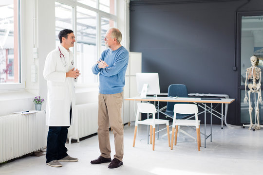 Doctor and patient standing face to face in medical practice