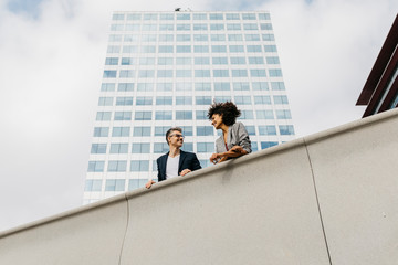Two colleagues talking outside office building