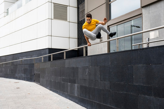 Young man jumping over railing
