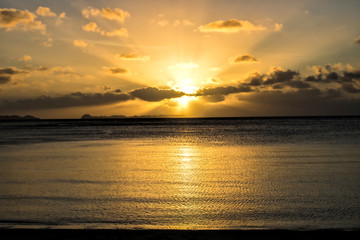 Fototapeta na wymiar Sunset over ocean with Rock Islands on Horizon