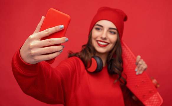 Hipster girl in red clothes taking selfie 