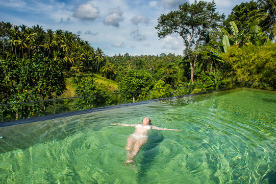 Indonesia, Bali, Ubud, Kamandalu Ubud Resort, Woman Enjoying The Beautiful Overflowing Pool