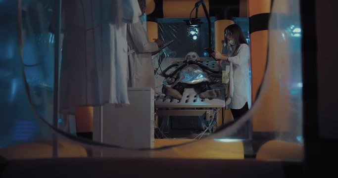 Scientists are exploring the alien alien, remove indicators from the instruments. Alien lies in the operational unit of the laboratory, connected to the observation devices.