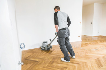 Versiegeln von Eichenparkett, Arbeiter mit spezialwerkzeug. Poliermaschine