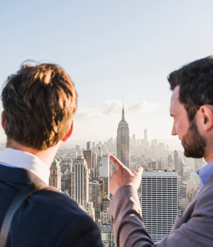 USA, New York City, two businessmen looking on cityscape on Rockefeller Center observation deck
