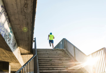 Young athlete jogging up stairs in the city