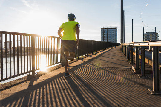 Young athlete jogging on a bridge in the city