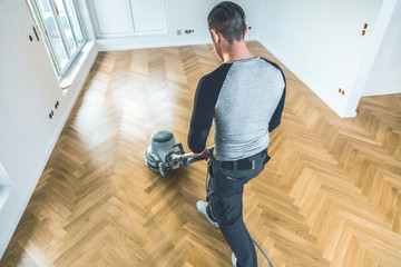 Versiegeln von Eichenparkett, Arbeiter mit spezialwerkzeug. Poliermaschine