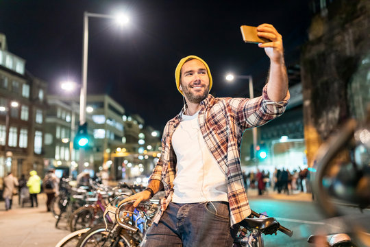 UK, London, man taking a selfie while commuting at night in the city