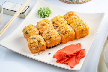 Baked rolls with scallop , spicy sauce, cream cheese and mango with rice on white plate with gold border. Asian menu
