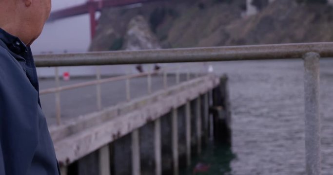 Fisher throwing crab back into water off pier - close up on hand
