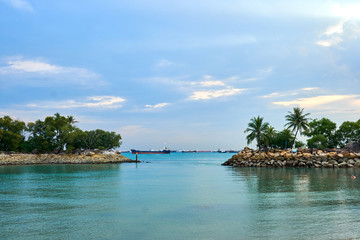 A view of ships resting on the ocean seen from the Siloso Beach, Singapore.
