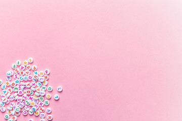 creative minimalist background, alphabet letter beads on pink, education concept