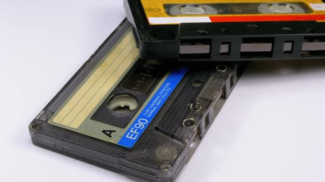 Two Audio Cassettes Rotate on White Background