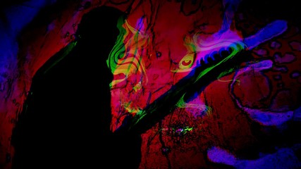 Man's silhouette playing guitar with psychedelic colors swirling about.