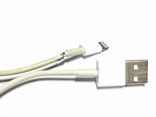 Broken phone charging cable on a white background.