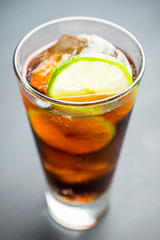 Cuba libre cocktail on the rustic background. Selective focus.