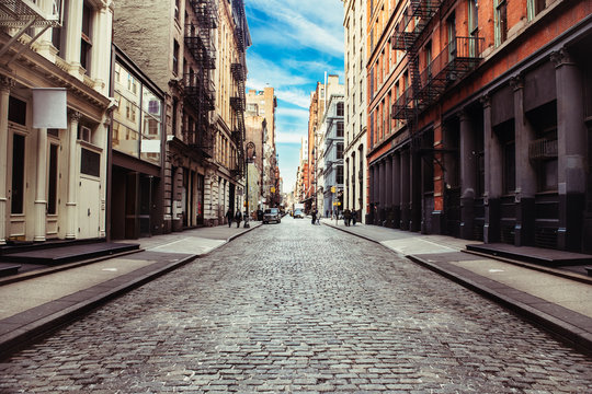 New York City old SoHo Downtown paving stone street with retail stores and luxury apartments