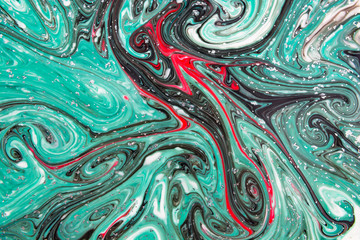 Abstract beautiful pattern of green,red and black marble.The Eastern style of Ebru painting on water with acrylic paints swirls.A stylish mix of colors,genuine luxury