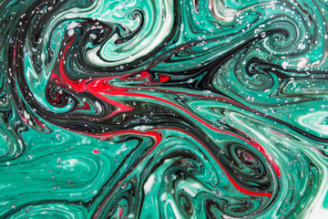Abstract beautiful pattern of green,red and black marble.The Eastern style of Ebru painting on water with acrylic paints swirls.A stylish mix of colors,genuine luxury