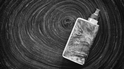 black and white, monochrome shot of high end stabilized wood regulated box mods with rebuildable...