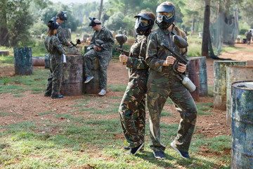 Fototapeta premium Portret młodych kobiet graczy paintball z pistoletami markera na zewnątrz