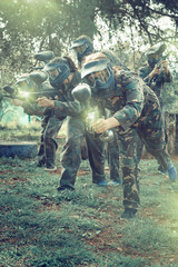 Portrait of team of adult people playing on paintball battlefiel