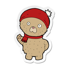 sticker of a cartoon teddy bear in winter hat and scarf