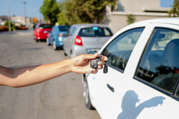 woman getting her key in the car. Concept of rent car or buying car.Travel vacation with rental car.travel with pleasure. learning to drive a car.Car key in hand.remote control car alarm systems.