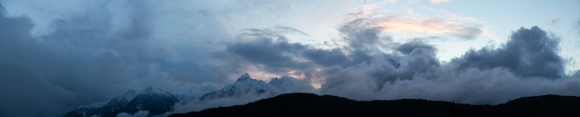 Striking and Dramatic Panoramic Canadian Landscape View of the Mountain Peaks during a cloudy sunset. Taken in Tantalus Lookout near Squamish and Whistler, North of Vancouver, BC, Canada.