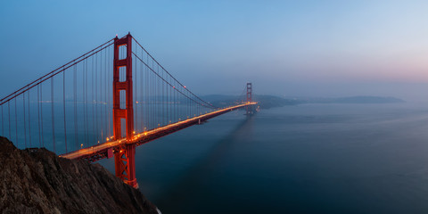 Beautiful panoramic view of Golden Gate Bridge during a hazy sunset. Taken in San Francisco, California, United States.