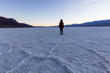 Woman walking on Salt Pan at the Badwater Basin, Death Valley National Park, California, United States.