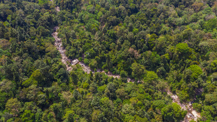 Fototapeta na wymiar Drone landscape of rocky river stream flowing through Thai jungle forest