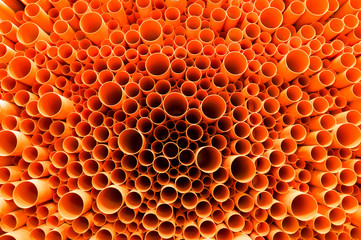 orange PVC pipes stacked in construction site