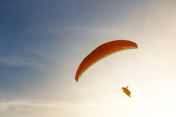Paraglider silhouette in the sunset sky