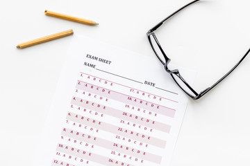 On the exam. Exam sheet, answer near glasses and pencil on white background top view space for text