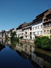 Fototapeta na wymiar River view sunny day in Strasbourg with relections of houses