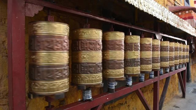 Prayer wheels in Jokhang temple. The characters (in Newari language & Tibetan) on the wheels are the mantras "Om Mani Padme Hum", each word means "sacred, bead, lotus flower, spirit of enlightenment"
