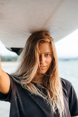 Surfer girl on beach - obrazy, fototapety, plakaty
