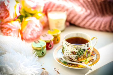 Breakfast composition. Cup of tea jams flowers and candle.