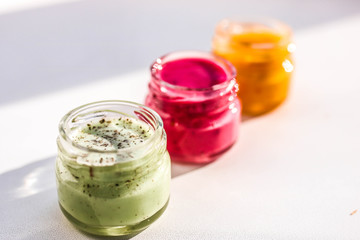 Three jars of colorful jams. Green red and yeallow honey souffle.