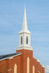 Church with red brick wall and white steeple