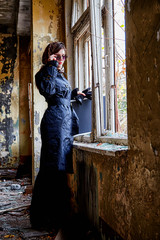 Girl in a black cloak, a scarf and a diplomat in an abandoned house. A spy in a secret meeting