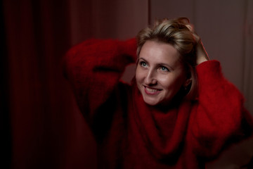 Portrait of a middle-aged woman in the room. Photography in the Studio. Photo shoot in a dark key